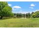 Lush backyard featuring a serene pond and well-manicured lawn at 509 Spruce Meadows Ln, Willow Springs, NC 27592