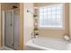 Well-lit bathroom featuring glass shower doors and a large grid pattern window at 509 Spruce Meadows Ln, Willow Springs, NC 27592