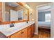 Bathroom featuring double sinks, wood framed mirror and a view of the bedroom at 509 Spruce Meadows Ln, Willow Springs, NC 27592