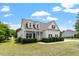 Charming two-story home featuring white siding, black shutters, and a welcoming front porch at 509 Spruce Meadows Ln, Willow Springs, NC 27592