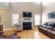Cozy living room showcases a fireplace, large windows, and hardwood flooring at 509 Spruce Meadows Ln, Willow Springs, NC 27592