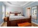 Bright main bedroom with a tray ceiling, window, and hardwood flooring at 509 Spruce Meadows Ln, Willow Springs, NC 27592