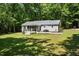 Aerial view of home with spacious lawn, back deck, and sunroom at 560 Parker Creek Rd, Holly Springs, NC 27540