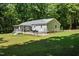 A spacious backyard featuring a screened-in porch, a deck with furniture, and tasteful landscaping at 560 Parker Creek Rd, Holly Springs, NC 27540