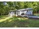 Beautiful home exterior featuring a sunroom, deck, lush lawn and landscaped flowerbeds at 560 Parker Creek Rd, Holly Springs, NC 27540