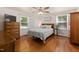 Bright bedroom with wood floors, two windows, and a ceiling fan for comfort at 560 Parker Creek Rd, Holly Springs, NC 27540