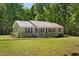 Charming single-story home with a metal roof and covered front porch nestled among trees at 560 Parker Creek Rd, Holly Springs, NC 27540