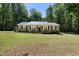 Welcoming single-story home featuring a metal roof and a charming front porch with outdoor seating at 560 Parker Creek Rd, Holly Springs, NC 27540