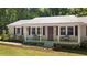 Inviting covered front porch with seating, beautiful landscaping, and charming curb appeal at 560 Parker Creek Rd, Holly Springs, NC 27540