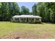 Well-maintained home with a metal roof, front porch, and manicured lawn at 560 Parker Creek Rd, Holly Springs, NC 27540