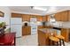 Traditional kitchen featuring oak cabinets, white appliances, and a granite-topped island at 560 Parker Creek Rd, Holly Springs, NC 27540