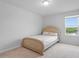 Bright bedroom features a beige bed frame, carpeted floor, and a sunlit window with an exterior view at 637 Marrian Dr, Clayton, NC 27520