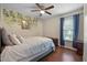 Bright bedroom featuring wood floors, a ceiling fan, and a decorative wall accent at 687 W Watson Rd, Benson, NC 27504