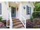 Charming front porch with brick steps, decorative door accents, and beautiful landscaping at 687 W Watson Rd, Benson, NC 27504