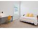 Bright bedroom featuring neutral carpet, a sleek desk, and a cozy daybed beneath a sunlit window at 7801 Charters End St, Willow Springs, NC 27592
