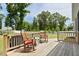Charming wooden deck with rocking chairs, overlooking a lush lawn and mature trees at 7801 Charters End St, Willow Springs, NC 27592