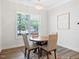 Cozy dining area with large window, chandelier, seating for four, and a decorative rug at 7801 Charters End St, Willow Springs, NC 27592