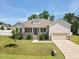 Charming exterior showcases covered porch, stone accents, manicured lawn, and attached garage at 7801 Charters End St, Willow Springs, NC 27592