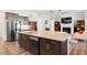 Open concept kitchen with island that connects the living room; stainless steel appliances and wooden cabinetry at 7801 Charters End St, Willow Springs, NC 27592