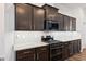 Kitchen area featuring modern appliances, dark wood cabinets, granite countertops, and white subway tile backsplash at 7801 Charters End St, Willow Springs, NC 27592