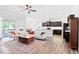 Bright, open living room boasts wood floors, stylish rug, modern furniture, and leads into the kitchen at 7801 Charters End St, Willow Springs, NC 27592