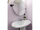 Powder room featuring a pedestal sink and round mirror against light lavender walls at 8610 Neuse Landing Ln # 103, Raleigh, NC 27616
