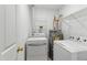 Functional laundry room with washer, dryer, water heater and shelving at 8610 Neuse Landing Ln # 103, Raleigh, NC 27616