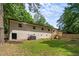 Expansive backyard featuring a patio, lush green grass, mature trees, and privacy fence at 908 W Garden St, Sanford, NC 27330
