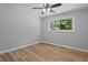 Neutral bedroom with wood-look floors, ceiling fan, and natural light from window at 908 W Garden St, Sanford, NC 27330