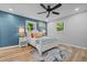 Comfortable bedroom featuring a plush bed, bright windows, ceiling fan, and wood-look flooring at 908 W Garden St, Sanford, NC 27330