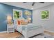 Comfortable bedroom featuring a plush bed, bright windows, ceiling fan, and wood-look flooring at 908 W Garden St, Sanford, NC 27330