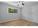 Bright bedroom with wood-look floors, ceiling fan, and natural light from window at 908 W Garden St, Sanford, NC 27330