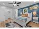 Stylish bedroom featuring a white bed frame, blue accent wall, and modern ceiling fan at 908 W Garden St, Sanford, NC 27330