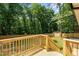 Overlooking a backyard with mature trees, new fence and lush green grass from the wooden deck at 908 W Garden St, Sanford, NC 27330