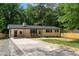 Charming single-story home with a long driveway, rocking chairs, and manicured front yard at 908 W Garden St, Sanford, NC 27330