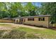 Charming single-story home with a long driveway, rocking chairs, and manicured front yard at 908 W Garden St, Sanford, NC 27330