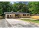 Charming single-story home with a long driveway, rocking chairs, and manicured front yard at 908 W Garden St, Sanford, NC 27330