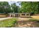 Charming single-story home with a long driveway, rocking chairs, and manicured front yard at 908 W Garden St, Sanford, NC 27330