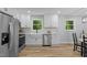 White kitchen featuring stainless steel appliances, a farmhouse sink, and modern fixtures at 908 W Garden St, Sanford, NC 27330