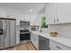Bright and modern kitchen with white cabinets, stainless steel appliances, and ample counter space at 908 W Garden St, Sanford, NC 27330