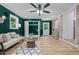 Stylish living room with dark green walls, closet doors, and light hardwood flooring at 908 W Garden St, Sanford, NC 27330
