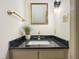 Elegant powder room features a black countertop, gold fixtures, and a framed mirror at 9417 Greenfield Dr, Raleigh, NC 27615
