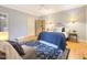 A bedroom featuring hardwood floors, bedside tables, and a cozy seating area with natural light from the windows at 9417 Greenfield Dr, Raleigh, NC 27615