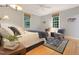 A bedroom with hardwood floors, sitting area and two large windows at 9417 Greenfield Dr, Raleigh, NC 27615