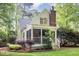 Rear exterior featuring a screened-in porch, complemented by mature trees and landscaping at 9417 Greenfield Dr, Raleigh, NC 27615