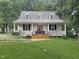 Inviting home with a lush green lawn, dormer windows, and a welcoming front porch at 9417 Greenfield Dr, Raleigh, NC 27615