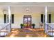 Inviting front porch with double doors, rocking chair, and black shutters, offering a relaxing outdoor space at 9417 Greenfield Dr, Raleigh, NC 27615