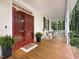 Charming front porch with rocking chairs, potted ferns, and a red double-door entrance at 9417 Greenfield Dr, Raleigh, NC 27615