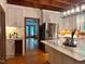 Kitchen features a wine fridge, white cabinetry, stainless steel appliances, and access to other rooms at 9417 Greenfield Dr, Raleigh, NC 27615