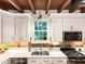 The kitchen is equipped with stainless steel appliances, quartz countertops, a large window and white cabinets at 9417 Greenfield Dr, Raleigh, NC 27615